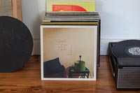 Vinyl records on floor next to turntable 