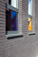 Grey brick building with coloured glass windows 