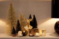 Golden Christmas decorations and candles on sideboard 