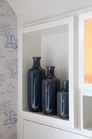Blue ceramic bottles in alcove shelf
