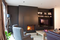 Living room with black painted feature wall and units 