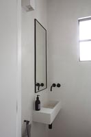 Modern white sink with black wall mounted taps 