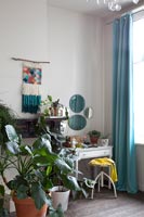 Houseplants in bedroom with classic dressing table 