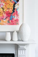 White ceramic vases on mantelpiece 