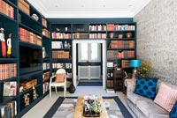 Dark blue painted wall to wall bookcases 