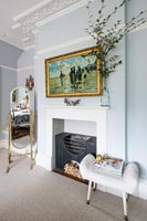 Fireplace and white upholstered stool in classic bedroom 
