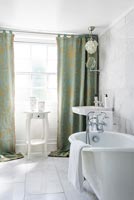 White bathroom with green and gold curtains 