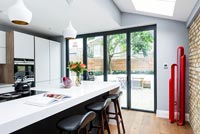 Modern kitchen with bi-fold doors and red sculpture 