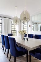 Black and white dining room with blue upholstered chairs 