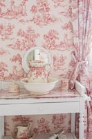 Pink and white vintage ceramics with matching wallpaper and curtains 