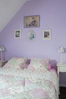 Country bedroom with patchwork bedding and purple wall 