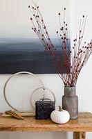 Vase of dried flowers and pumpkin on hallway table 
