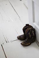 Old leather cowboy boots used as doorstop 