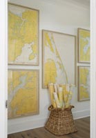Framed maps and a basket of rolled maps in hallway 