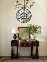 Decorative grate on circular internal window above console table 