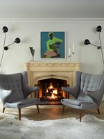 Vintage furniture in modern living room with lit fire 