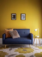 Modern blue sofa in yellow room