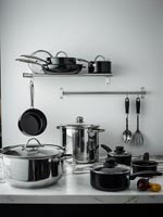 Black and chrome pots and pans in kitchen 