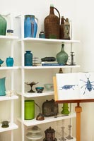 Two shelving units filled with glassware and ceramics on display 