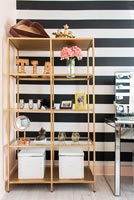 Shelf unit with black and white striped wall  