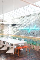 Neon art on stone wall of industrial style dining room 