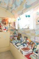 Books and toys in vintage caravan used as childrens room 
