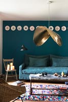 Unusual pendant light in modern living room with dark blue walls 