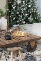 Large wooden coffee table and Christmas tree in modern living room 