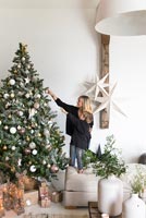 Woman and child decorating Christmas tree together 