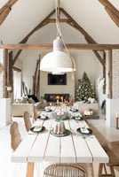 Modern country dining room laid for Christmas in open plan living space 
