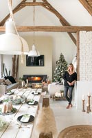 Woman in open plan living and dining room decorated for Christmas 