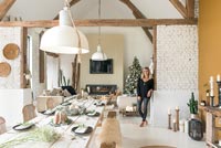 Woman in open plan living space decorated for Christmas 