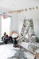 Woman reading to child in black and white childrens bedroom 
