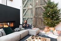 Woman relaxing in modern country living room decorated for Christmas 