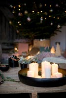 Circular tray of lit candles and Christmas tree 