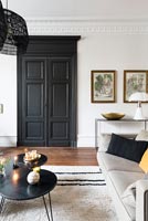 Black painted interior door in modern living room with period details 