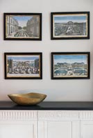 Framed paintings and photographs on wall 