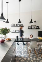 Child eating at table in modern kitchen-diner 