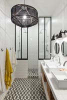 Black and white bathroom with patterned tiling on floor 