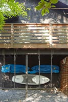 Canoes and paddle boards stored under house 