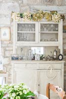 Dried flower garland on dresser in country dining room 