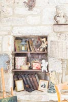 Stone wall alcove shelves with display of books and ornaments 