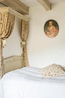 Country bedroom with classic portrait painting on wall 