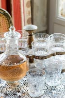 Antique glassware and accessories on lace tablecloth covered dining table 