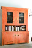 Orange painted dresser with recipe books