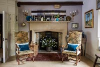 Armchairs either side of large fireplace in country living room 