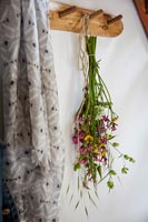 Flower arrangement hung from coat hook in hallway