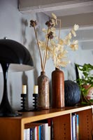Seed heads in vases on shelf 