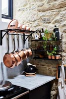 Copper pots on storage rack in modern kitchen 