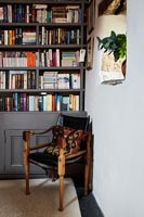 Armchair next to large bookcase 